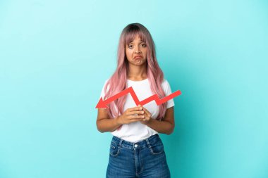 Mavi arka planda izole edilmiş pembe saçlı melez bir kadın aşağıya doğru ok atıyor ve üzgün bir ifadeyle.