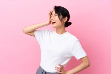 Pembe arka planda izole edilmiş genç Vietnamlı kadın çok gülümsüyor.