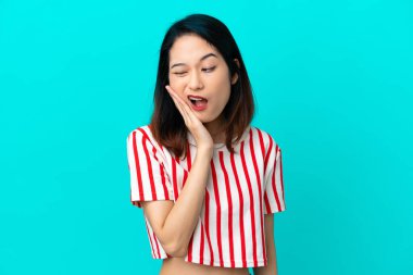 Genç Vietnamlı kadın mavi arka planda diş ağrısı ile izole edilmiş.