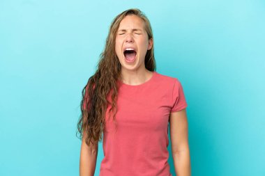 Kafkasyalı genç bir kadın mavi arka planda izole edilmiş ve ağzı açık bağırıyor.