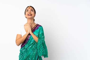 Beyaz arka planda izole edilmiş genç Hintli kadın avuç içlerini bir arada tutuyor. İnsan bir şey ister.