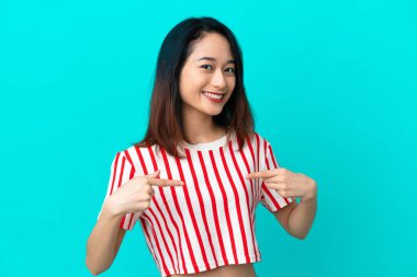 Genç Vietnamlı kadın mavi arka planda yalnız gururlu ve kendini beğenmiş.