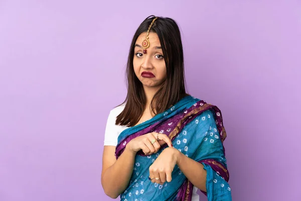 紫の背景に孤立した若いインド人女性は 遅刻のジェスチャーを作ります — ストック写真