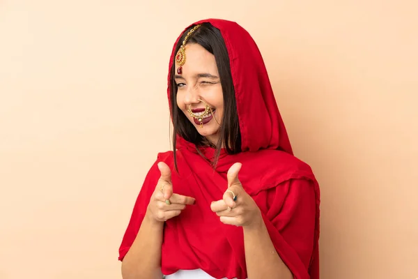 Jovem Indiana Isolada Fundo Bege Apontando Para Frente Sorrindo — Fotografia de Stock