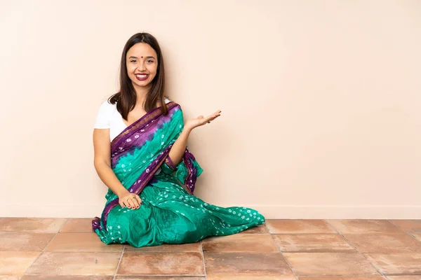 Mujer India Joven Sentada Suelo Sosteniendo Espacio Copia Imaginario Palma —  Fotos de Stock