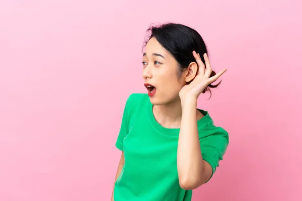 Jovem Vietnamita Isolada Fundo Rosa Ouvindo Algo Colocando Mão Orelha — Fotografia de Stock