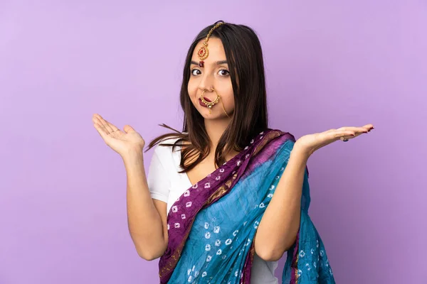 紫の背景に孤立した若いインド人女性は疑問ジェスチャーを作る — ストック写真