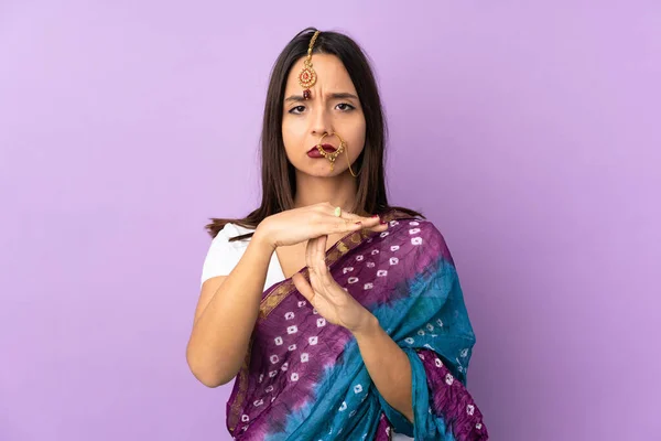 若いインド人女性は紫色の背景に隔離された時間を作るジェスチャー — ストック写真