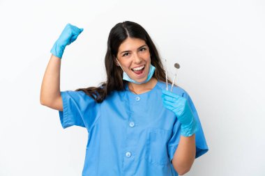 İzole edilmiş beyaz arkaplan üzerinde aletleri tutan dişçi kadın zaferi kutluyor