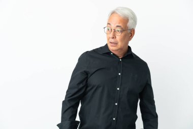 Orta yaşlı Brezilyalı adam beyaz arka planda izole edilmiş. Yan tarafa bakarken sürpriz jest yapıyor.