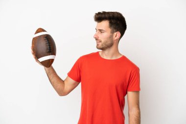 Beyaz arka planda ragbi oynayan beyaz tenli genç bir adam.