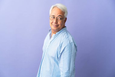 Mor arka planda izole edilmiş orta yaşlı Brezilyalı bir adam. Portre