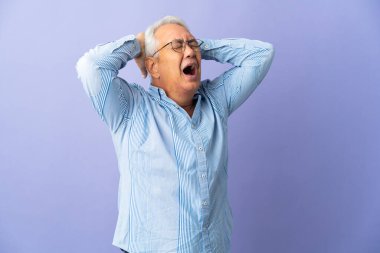 Mor arka planda izole edilmiş orta yaşlı Brezilyalı bir adam bunalımda.