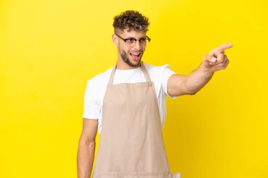 Restoran garsonu. Sarışın adam sarı arka planda izole edilmiş.