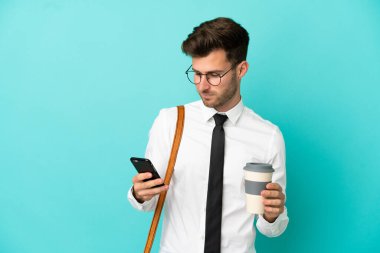 İş adamı izole edilmiş arka planda kahve ve cep telefonu tutuyor.