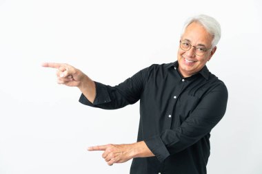 Beyaz arka planda izole edilmiş orta yaşlı Brezilyalı bir adam parmak göstererek bir ürün sunuyor.