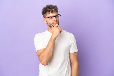 Teslimatçı beyaz adam mor arka planda izole edilmiş ve yukarı bakıyor.