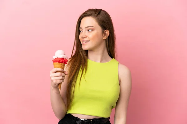 Tiener Meisje Met Een Cornet Ijs Geïsoleerde Roze Achtergrond Kijken — Stockfoto