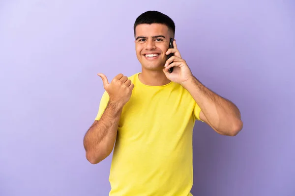 Joven Hombre Guapo Utilizando Teléfono Móvil Sobre Fondo Púrpura Aislado —  Fotos de Stock