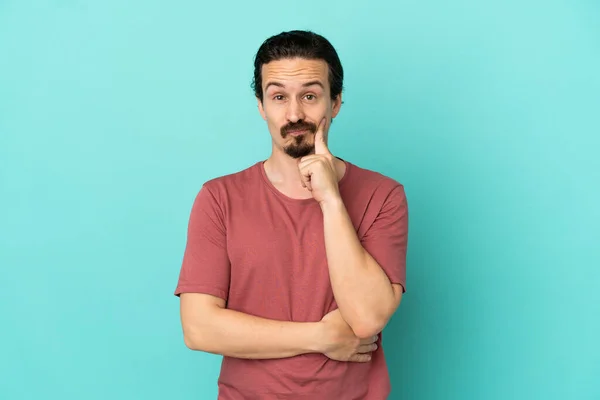 Joven Hombre Caucásico Aislado Sobre Fondo Azul Pensando —  Fotos de Stock