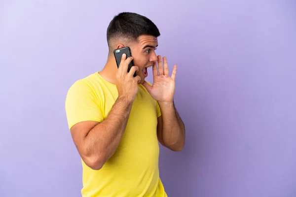 Young Handsome Man Using Mobile Phone Isolated Purple Background Shouting — Stock Photo, Image