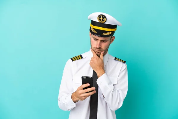 Avión Piloto Caucásico Aislado Sobre Fondo Azul Pensando Enviando Mensaje —  Fotos de Stock