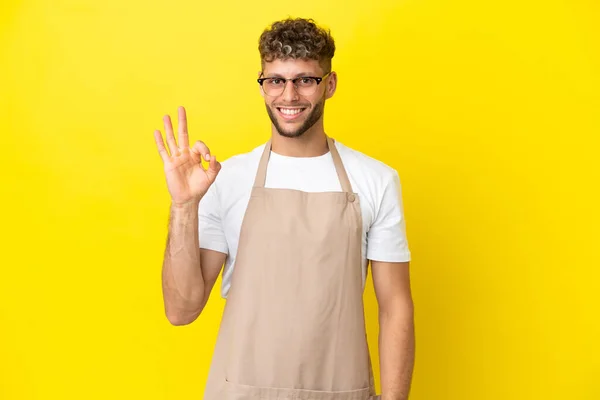 Restauracja Kelner Blondynka Człowiek Izolowany Żółtym Tle Pokazując Znak Palcami — Zdjęcie stockowe