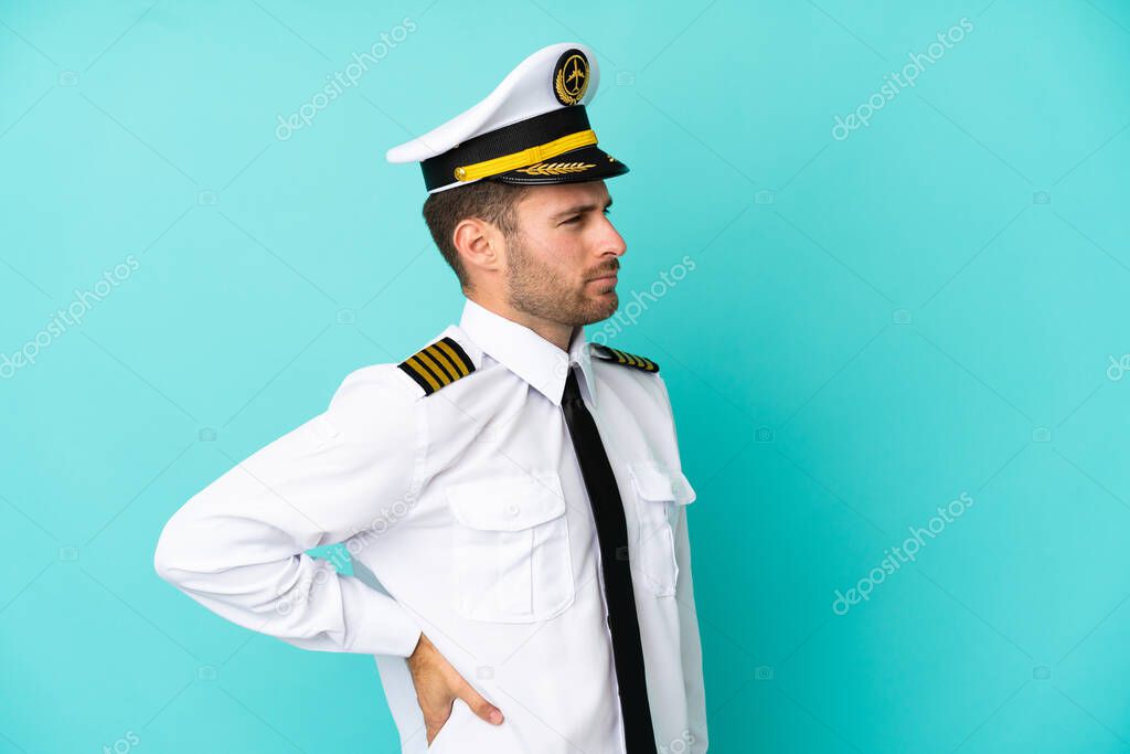 Airplane caucasian pilot isolated on blue background suffering from backache for having made an effort