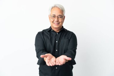 Beyaz arka planda izole edilmiş orta yaşlı Brezilyalı bir adam bir ilan vermek için avucunda hayali bir metin tutuyor.