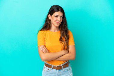 Mavi arka planda izole edilmiş genç beyaz kadın üzgün hissediyor.