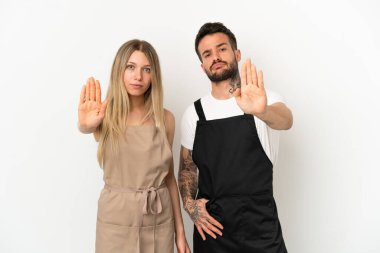 İzole edilmiş beyaz arka planda bir restoran garsonu yanlış olduğunu düşündüğü bir durumu inkar etmekten vazgeçiyor.