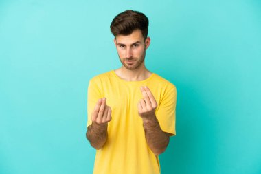 Beyaz tenli yakışıklı adam mavi arka planda izole edilmiş para hareketi yapıyor ama mahvolmuş.
