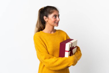 Elinde beyaz arka planda izole edilmiş bir hediye tutan genç bir kadın.