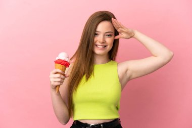 Kornet dondurması olan genç bir kız pembe arka planda, sürpriz bir ifadeyle.
