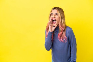 Soyutlanmış sarı arka planda genç bir kadın ağzı açık bağırıyor.