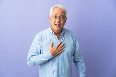 Mor arka planda izole edilmiş orta yaşlı Brezilyalı bir adam kendini gösteriyor.