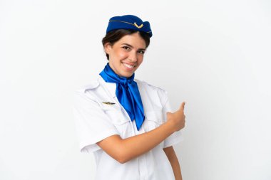 Uçak hostesi beyaz arka planda izole edilmiş beyaz kadın geriye doğru işaret ediyor.