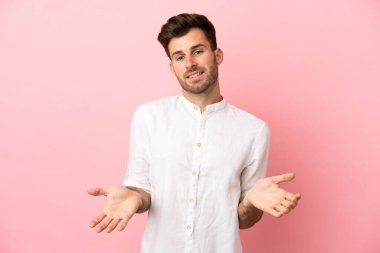 Beyaz tenli yakışıklı bir adam pembe arka planda izole edilmiş mutlu ve gülümsüyor.