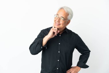 Orta yaşlı Brezilyalı bir adam beyaz arka planda izole edilmiş bir şekilde yukarı bakarken bir fikir düşünüyor.