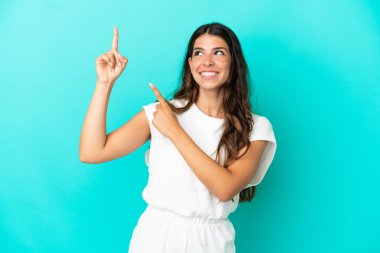 Mavi arka planda izole edilmiş genç beyaz kadın işaret parmağıyla işaret etmek harika bir fikir.