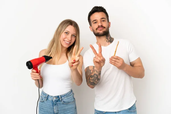 Casal Segurando Secador Cabelo Escovando Dentes Sobre Fundo Branco Isolado — Fotografia de Stock