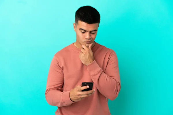 Jovem Homem Bonito Sobre Fundo Azul Isolado Pensando Enviando Uma — Fotografia de Stock