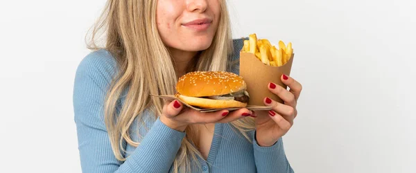 Arkaplanda Kızarmış Cips Çizburger Tutan Genç Sarışın Kadın — Stok fotoğraf