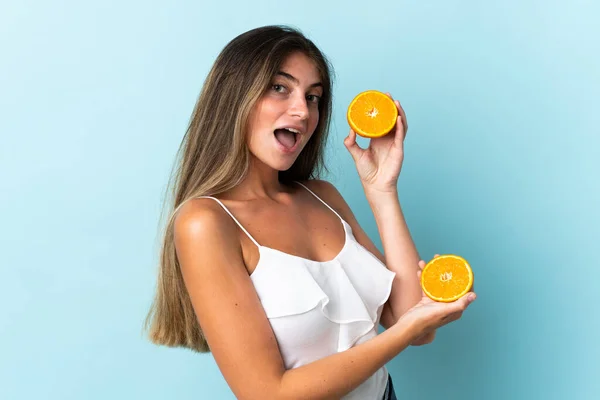 Ung Kaukasisk Kvinna Isolerad Blå Bakgrund Håller Orange — Stockfoto