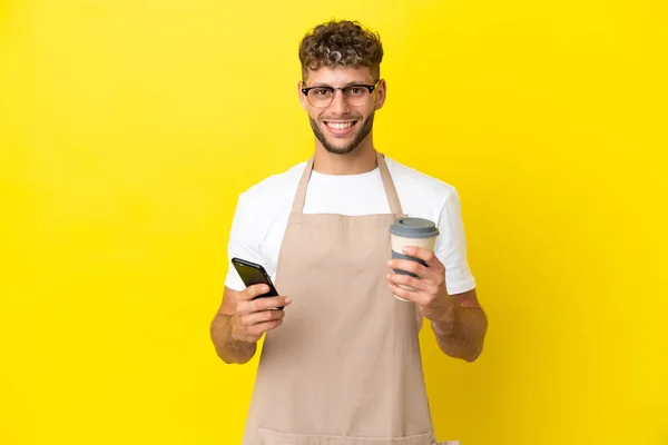 Restaurante Garçom Loiro Homem Isolado Fundo Amarelo Segurando Café Para — Fotografia de Stock