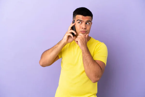 Joven Hombre Guapo Utilizando Teléfono Móvil Sobre Fondo Púrpura Aislado —  Fotos de Stock