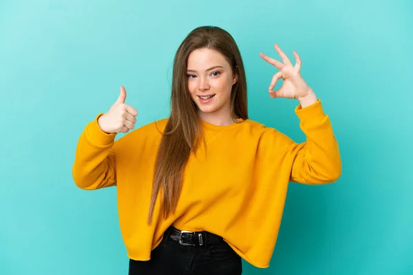 Дівчинка Підліток Над Ізольованим Синім Фоном Показує Знак Великий Палець — стокове фото