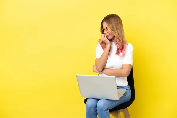 Young Woman Sitting Chair Laptop Isolated Yellow Background Having Doubts — Stock Photo, Image