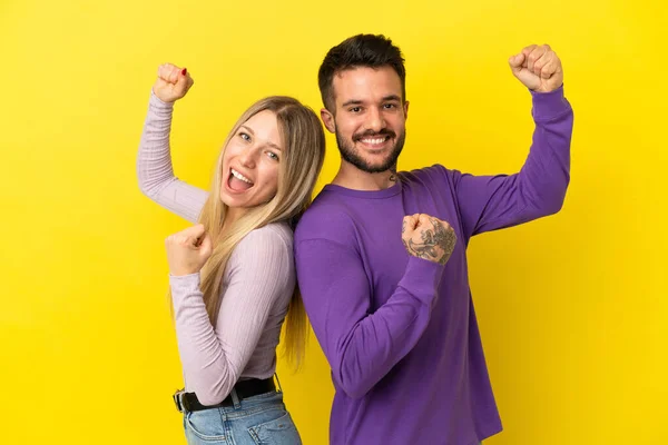 Casal Jovem Sobre Fundo Amarelo Isolado Celebrando Uma Vitória — Fotografia de Stock