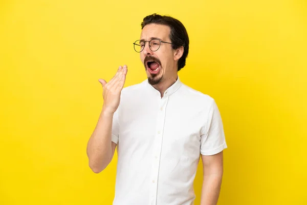 Hombre Joven Caucásico Aislado Sobre Fondo Amarillo Bostezando Cubriendo Boca — Foto de Stock